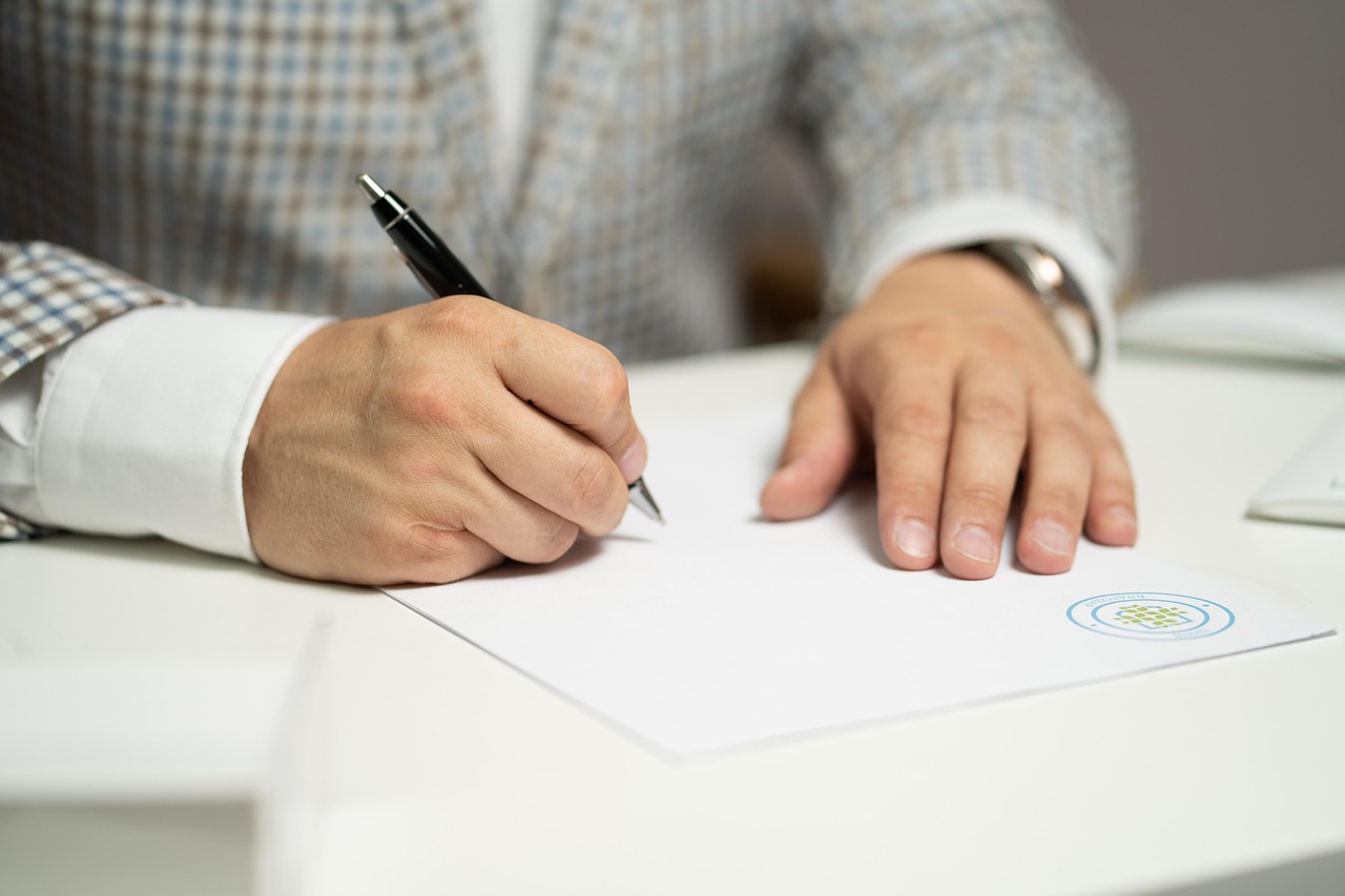 Hombre firmando un documento en representación del derecho Penal Económico.