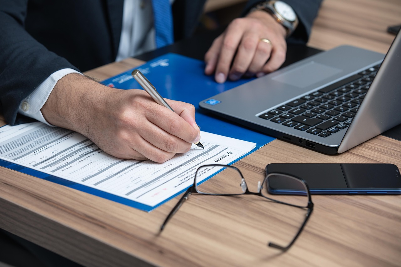 Mano rellenando un formulario como representación del derecho procesal